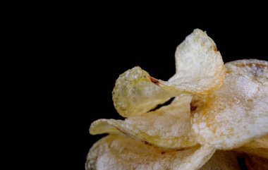 Siyah arka planda patates cipsi. Çıtır patates cipsi..