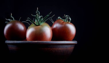 Three ripe tomatoes in earthenware. Cumato tomatoes.
