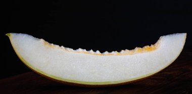 A piece of ripe melon on a black background.