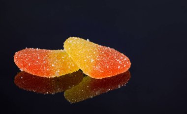 Two marmalade hearts with their mirror reflection. Marmalade candy in the form of a heart.