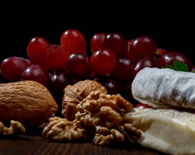 A circle of camembert cheese lies on a wooden board.