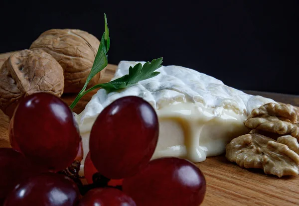 Piece Camembert Cheese Nuts Grapes Lie Wooden Board Camembert Cheese — Foto de Stock