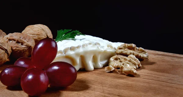 Piece Camembert Cheese Nuts Grapes Lie Wooden Board Camembert Cheese — Stock fotografie