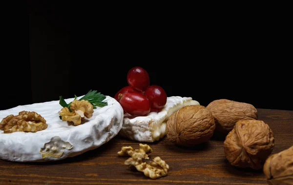 Circle Camembert Cheese Lies Wooden Board Piece Cheese Walnuts Grapes — Foto de Stock