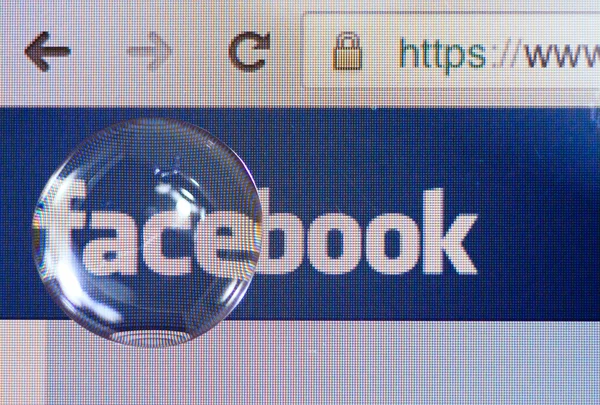 Логотип Facebook на экране ipad снят через большую каплю воды — стоковое фото