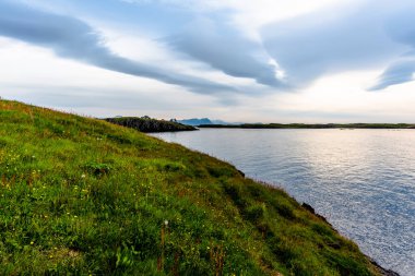 Batı İzlanda 'daki Stikkysholmur limanının üzerindeki Sugandisey yarımadasının burunlarından gün batımı.
