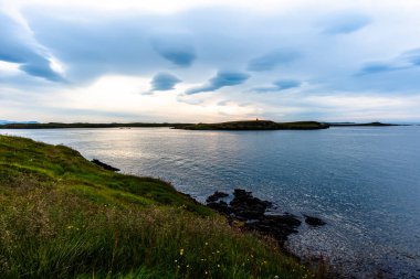 Batı İzlanda 'daki Stikkysholmur limanının üzerindeki Sugandisey yarımadasının burunlarından gün batımı.