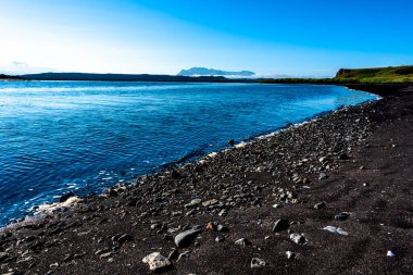 Kuzey İzlanda 'daki Vatnsnes yarımadasında ayak izleri ve çakıl taşları olan siyah sahil.