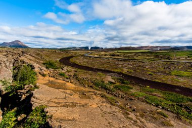 İzlanda 'nın Nordurping belediyesinde Husavik yakınlarındaki Mivatn Gölü' nde bulutlu mavi gökyüzü olan kumda lav kayaları var.