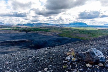 İzlanda 'nın Nordurping belediyesinde Husavik yakınlarındaki Mivatn Gölü' nde bulutlu mavi gökyüzü olan kumda lav kayaları var.