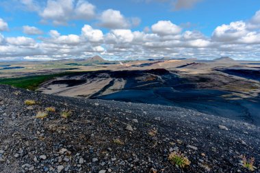 İzlanda 'nın Nordurping belediyesinde Husavik yakınlarındaki Mivatn Gölü' nde bulutlu mavi gökyüzü olan kumda lav kayaları var.