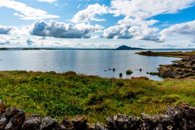 Bulutlar, İzlanda 'nın Nordurping belediyesinde Husavik yakınlarındaki Myvatn Gölü' nde gün batımında yansıtılır.