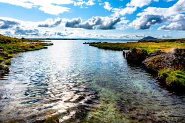 Bulutlar, İzlanda 'nın Nordurping belediyesinde Husavik yakınlarındaki Myvatn Gölü' nde gün batımında yansıtılır.