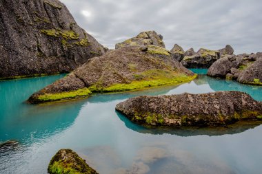 Borgarfiordur Eystri yakınlarındaki bir fırtınada dev kayalar, eğimli ve pürüzlü dağlarla çevrili çayırlardan ve göllerden oluşan bir vaha, muhtemelen son Buzul Çağı 'nın sonunda buzulların geri çekilmesiyle terk edilmiş çok büyük kaya yığınlarıyla çevrili.
