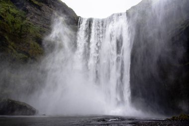 Yazın Skogafoss şelaleleri, dağların yeşili ve İzlanda 'da Vik yakınlarında akan sular.