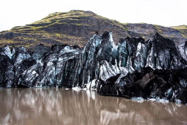 アイスランドのヴィク付近の火山から氷河湖が降下する前の噴火によるすすで覆われたSolheimajokull氷河 — ストック写真