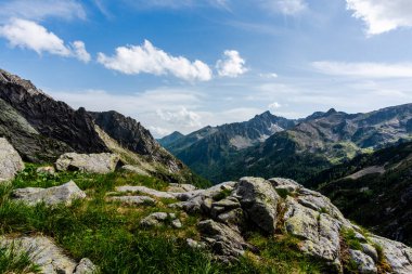 picchi di granito su cielo azzurro e nuvole bianche con valli e prati verdi facendo treckking e hiking o scalndo sulle cime Dell Lagorai a Trento Italia