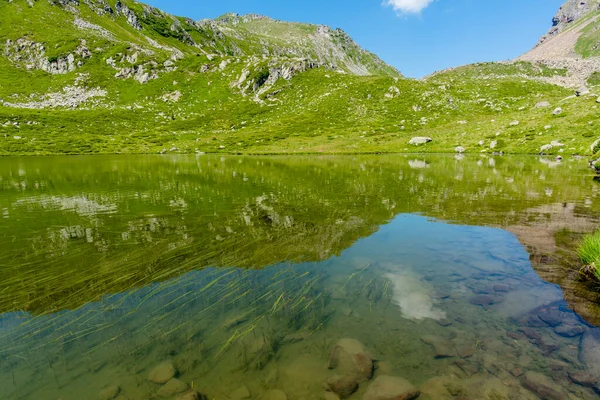 花岗岩山峰反映在意大利Val Campelle Trento的Lagorai山脉山峰之间的一个小高山湖中平静的水面上 — 图库照片