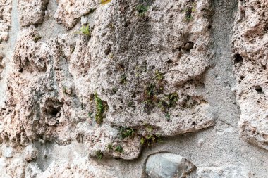 Ermenistan, Haghartsin, Eylül 2021. Pembe Tuff 'tan yapılmış eski bir taş duvarın parçası..