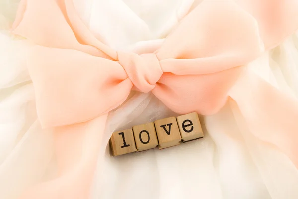 Love wording and dress with peach bow ribbon — Stock Photo, Image