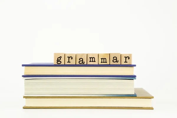 Gramática palavra sobre selos de madeira e livros — Fotografia de Stock