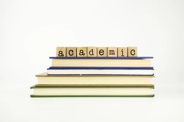 Academische woord op hout stempels en boeken — Stockfoto