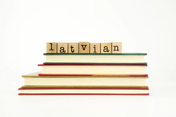 Latvian language word on wood stamps and books — Stock Photo, Image