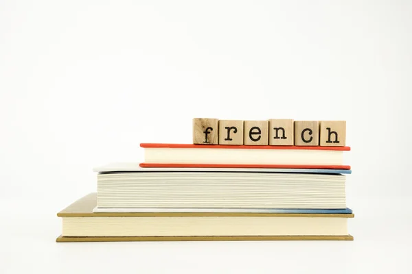 French language word on wood stamps and books — Stock Photo, Image