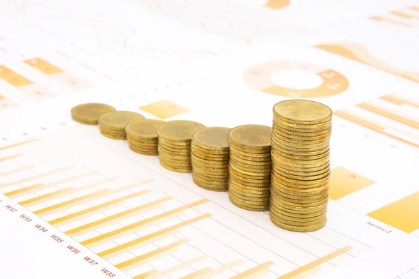 Raising stacks of golden coins on business graph background — Stock Photo, Image