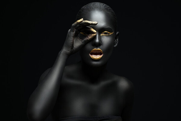 beauty portrait of a dark-skinned girl with golden makeup