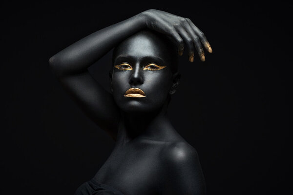 beauty portrait of a dark-skinned girl with golden makeup