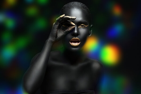 beauty portrait of a dark-skinned girl with golden makeup