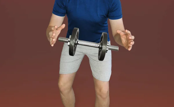 Dumbbell hanging in the air between the hands of a sports guy. Levitating dumbbell. Dumbbell in the air between the hands.
