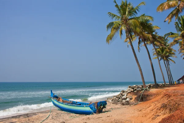 Barco de pesca azul fica em uma praia deserta — Fotografia de Stock