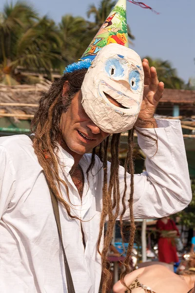 Um homem não identificado ajusta sua máscara de carnaval no festival anual de Freaks, praia de Arambol, Goa, Índia, 5 de fevereiro de 2013 — Fotografia de Stock