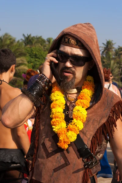 Неизвестный мужчина в ожерелье из цветов и солнцезащитных очков, разговаривающий по телефону на ежегодном фестивале уродов, пляж Арамбол, Гоа, Индия, 5 февраля 2013 г. . — стоковое фото