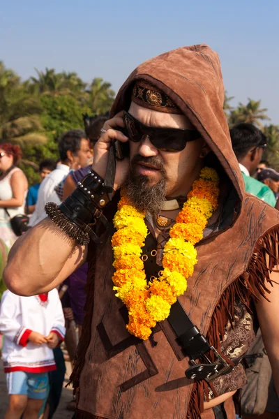 A man in a necklace of flowers and sun glasses talking on the phone at the annual festival of Freaks, Arambol beach, Goa, India, February 5, 2013. — Stock Photo, Image