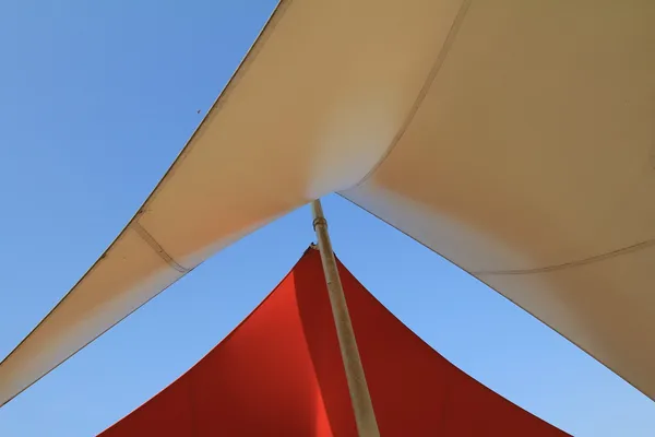 在蓝天的映衬的杆子上的架空篷 — 图库照片