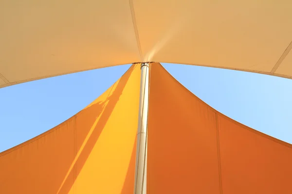 在蓝天的映衬的杆子上的架空篷 — 图库照片