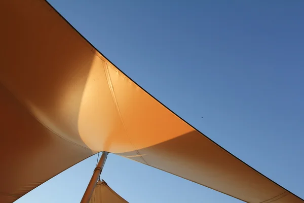 Sonnensegel auf einer Stange vor blauem Himmel — Stockfoto