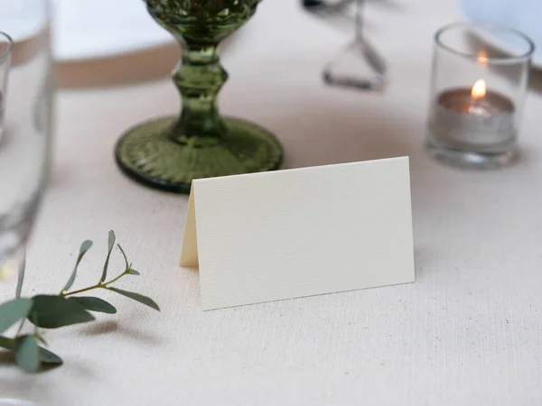 Mockup white blank space card, for Name place, Folded, greeting, invitation on wedding table setting background. with clipping path\