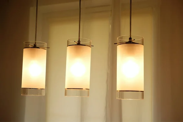 Три Светящихся Лампы Освещены Над Столом — стоковое фото