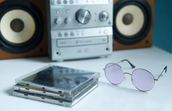 mini stereo system from the 90s and old cds on white shelf