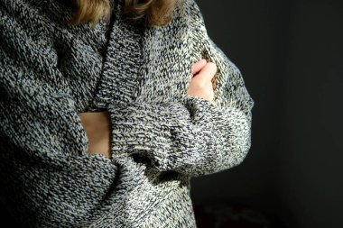 Rusya 'nın Ukrayna savaşı nedeniyle soğuk kışa hazırlanan sıcak yün hırkalı genç bir kadının yakın plan fotoğrafları.