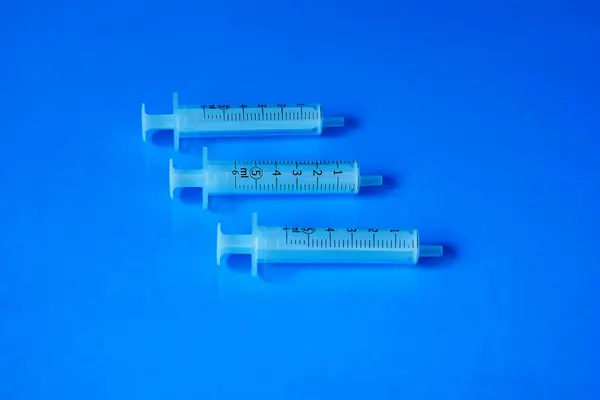 Kis Műanyag Orvosi Fecskendők Kék Háttérrel — Stock Fotó