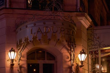 Champs Elysees 'deki lüks bir pastaneden geceleyin aydınlatılmış pencere bakkalı - Paris, Fransa