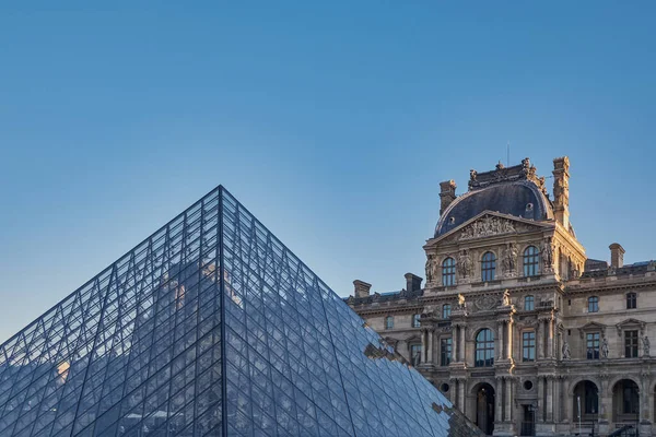 日の出に有名なルーブル美術館とガラスのピラミッドをご覧ください 世界で最も訪問された博物館とパリ フランスの主要な観光スポットの1つ — ストック写真
