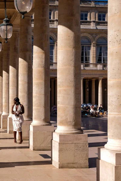 在法国巴黎皇家宫的柱子上 身穿白衣的年轻黑人女子正在拍照 有影响力的人 — 图库照片