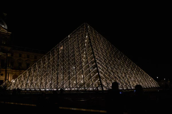 夜には有名なルーブル美術館やガラスのピラミッドをご覧ください 世界で最も訪問された博物館とパリ フランスの主要な観光スポットの1つ — ストック写真