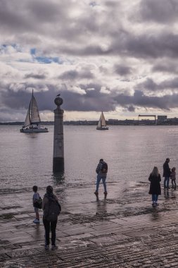 Portekiz, Lizbon 'daki Cais da Coluna' da Havanın Tagus veya Tejo Nehri 'nde Havanın Tadını Çıkaranlar